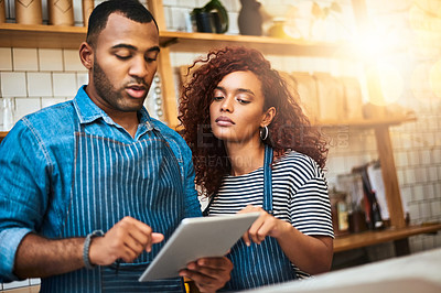 Buy stock photo Cropped shot of an affectionate young couple working on a tablet in their coffee shop