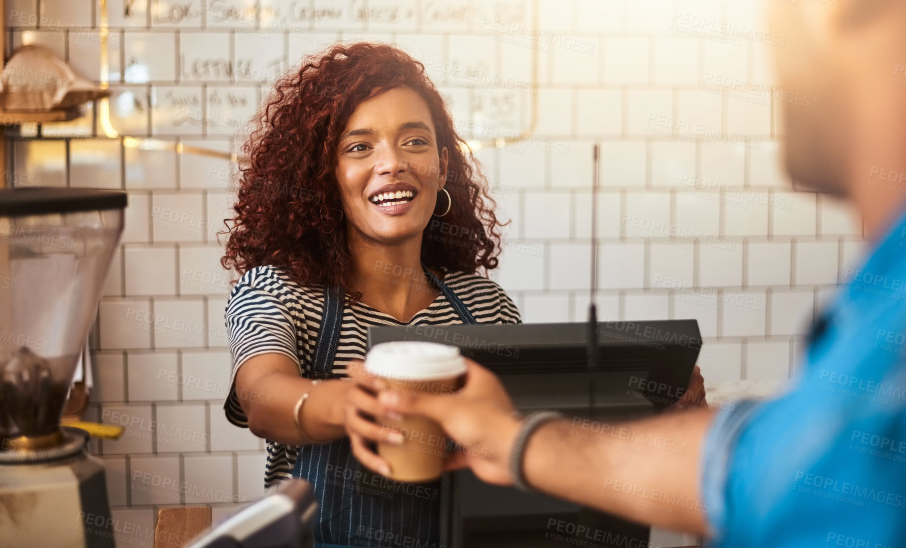 Buy stock photo Shot of a young barista serving a cup of coffee to a customer in a cafe