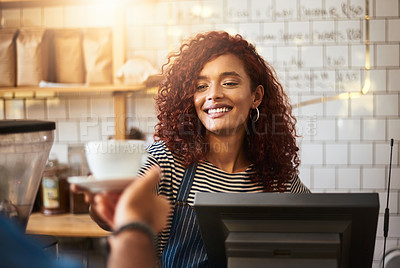 Buy stock photo Shot of a young barista serving a cup of coffee to a customer in a cafe