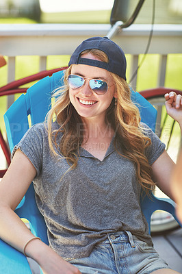 Buy stock photo Shot of an attractive young woman relaxing on a deck chair outdoors