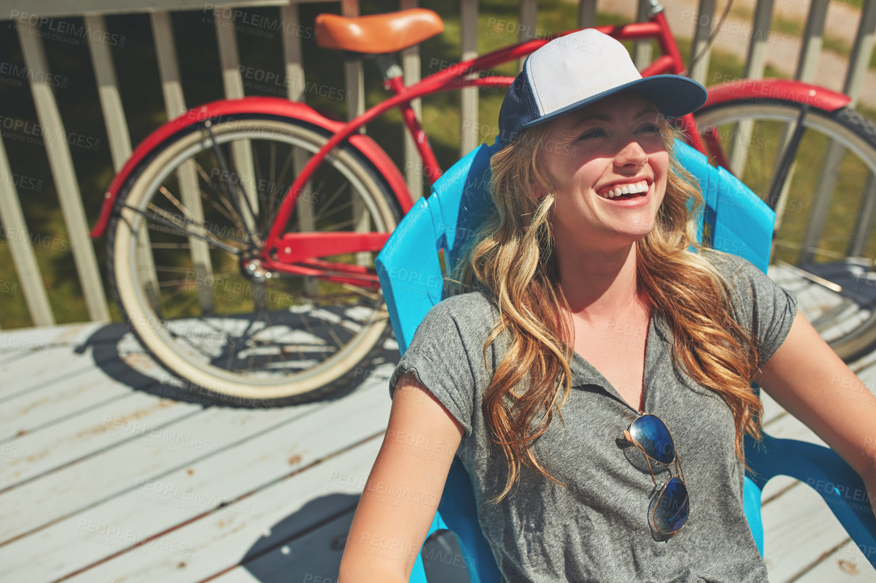 Buy stock photo Shot of an attractive young woman relaxing on a deck chair outdoors