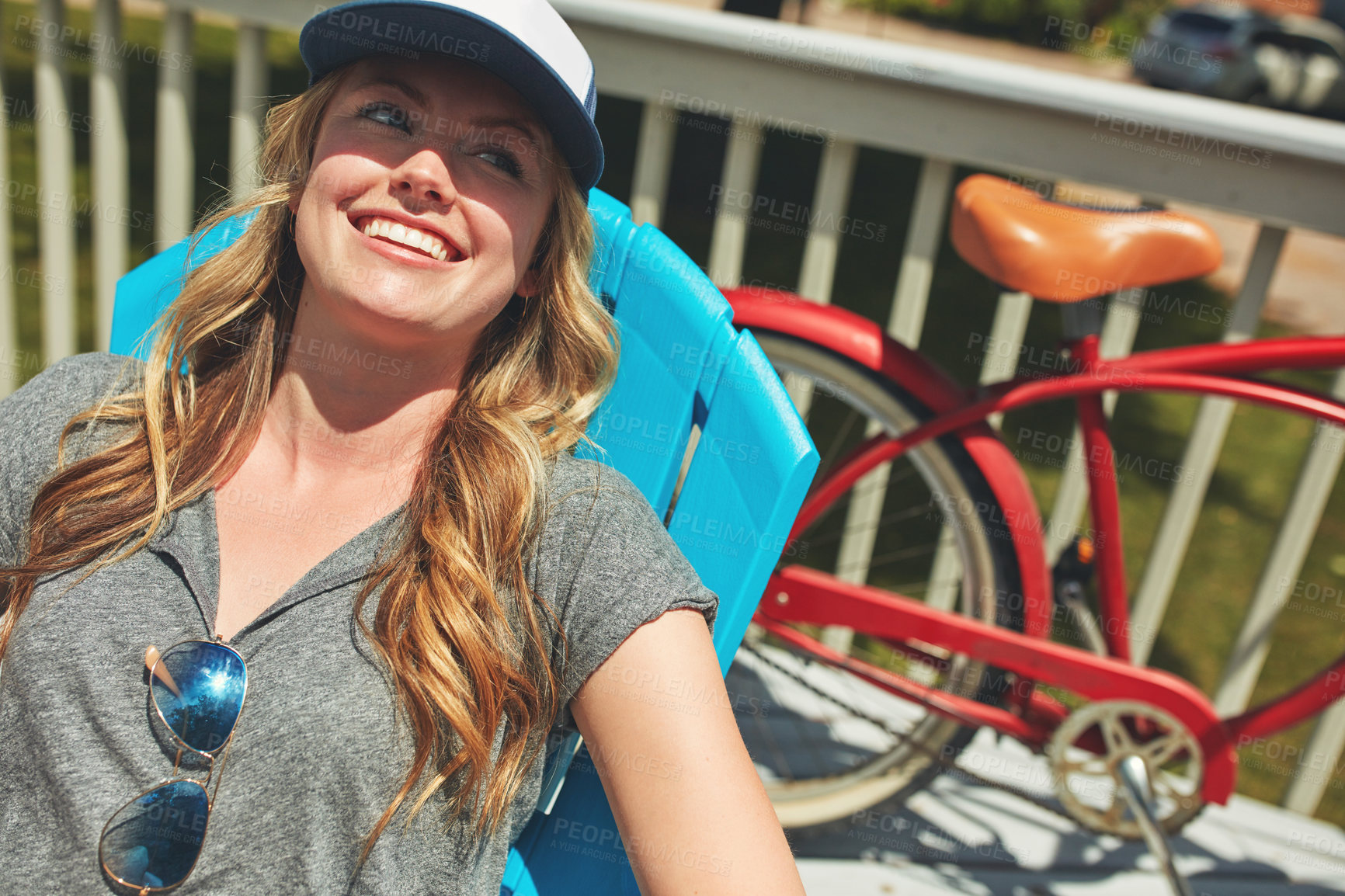 Buy stock photo Shot of an attractive young woman relaxing on a deck chair outdoors