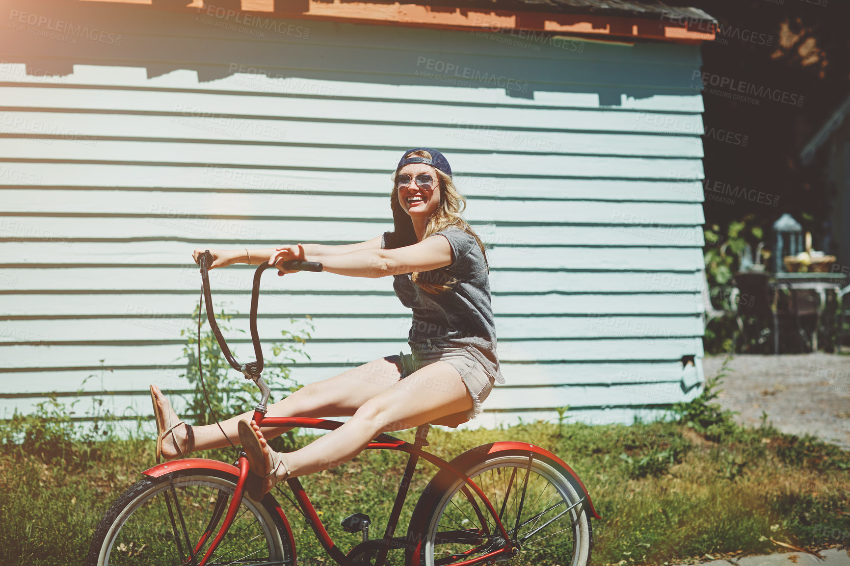 Buy stock photo Shot of an attractive young woman riding a bicycle outdoors