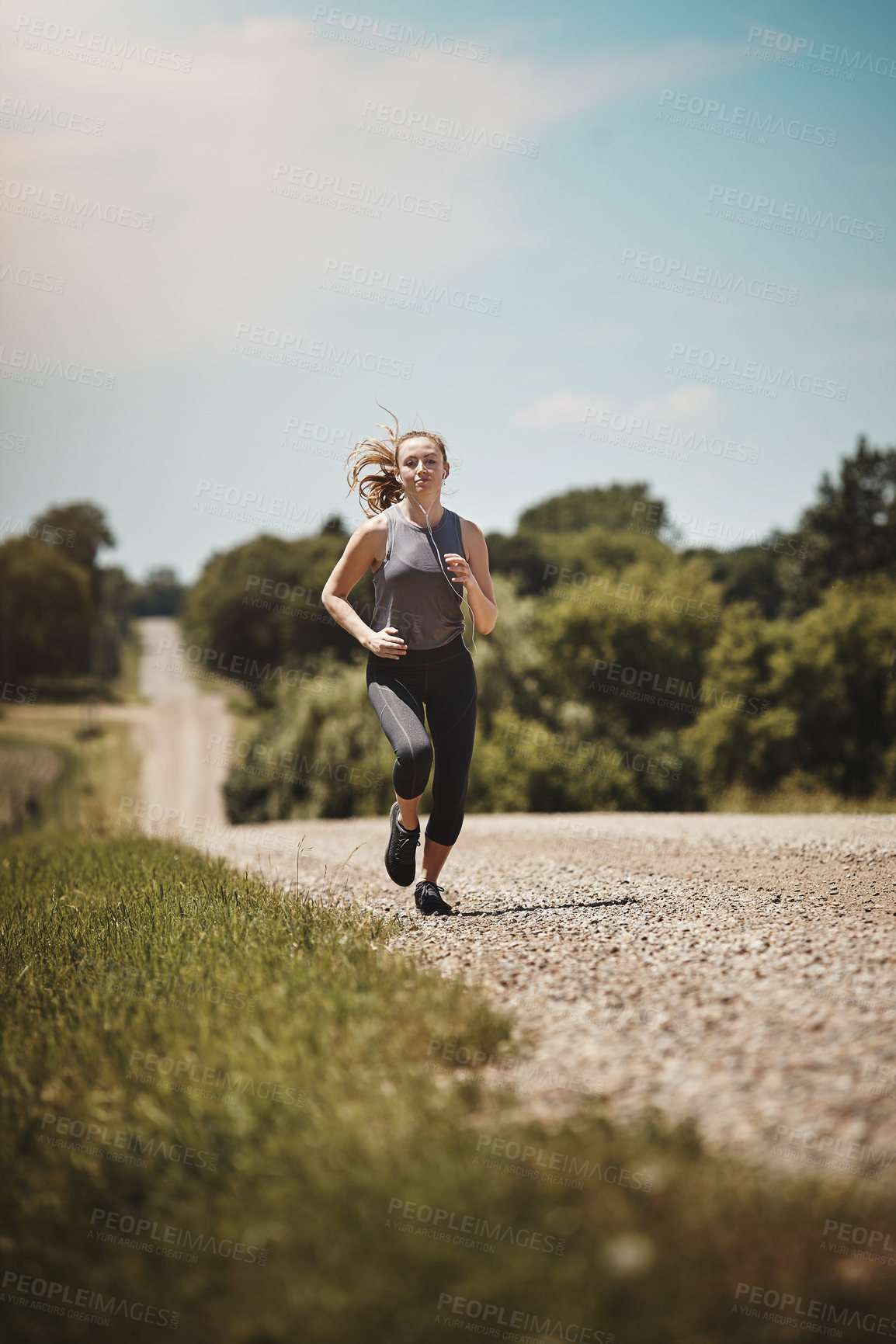 Buy stock photo Shot of a young woman out on a trail run
