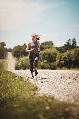 Buy stock photo Earphones, workout and woman running on path at park for healthy body, wellness or fitness. Music, trail runner and cardio training in nature for sport, sprint or jog outdoor to exercise in summer