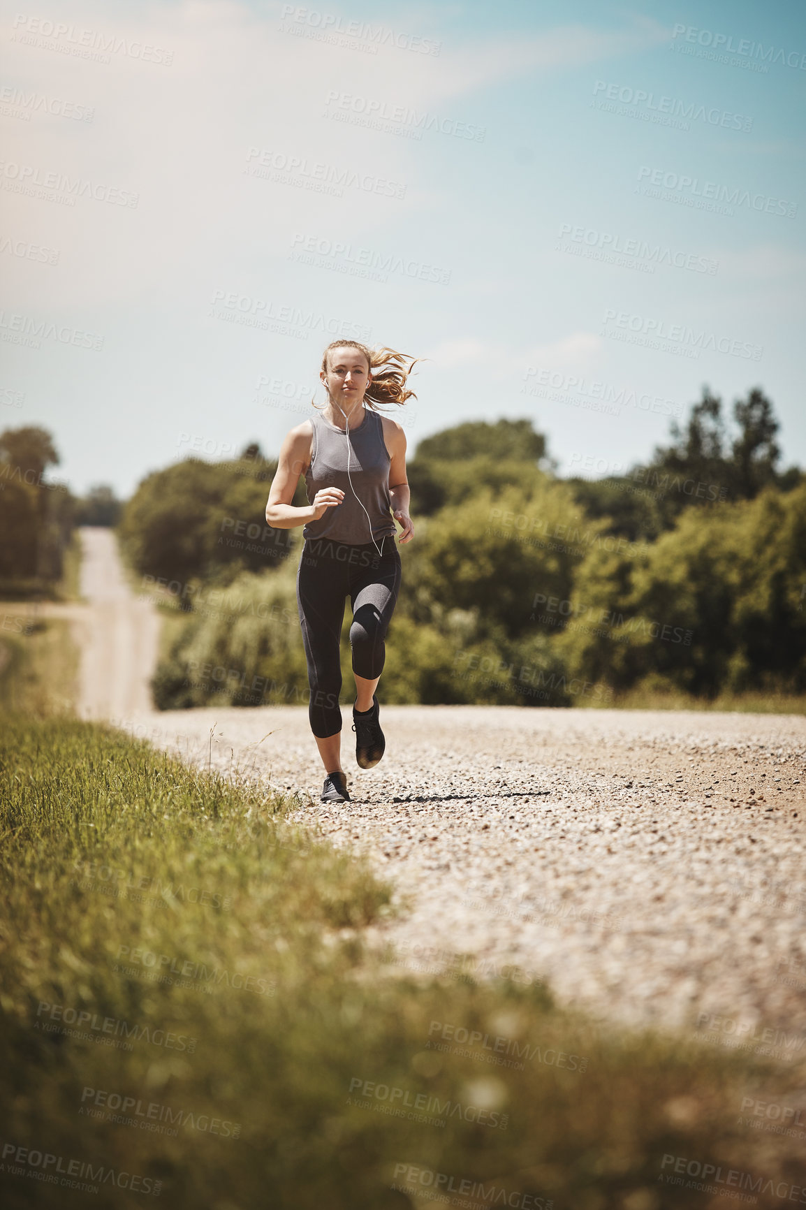 Buy stock photo Shot of a young woman out on a trail run