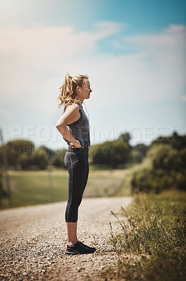 Buy stock photo Shot of a young woman taking a break while out for a run