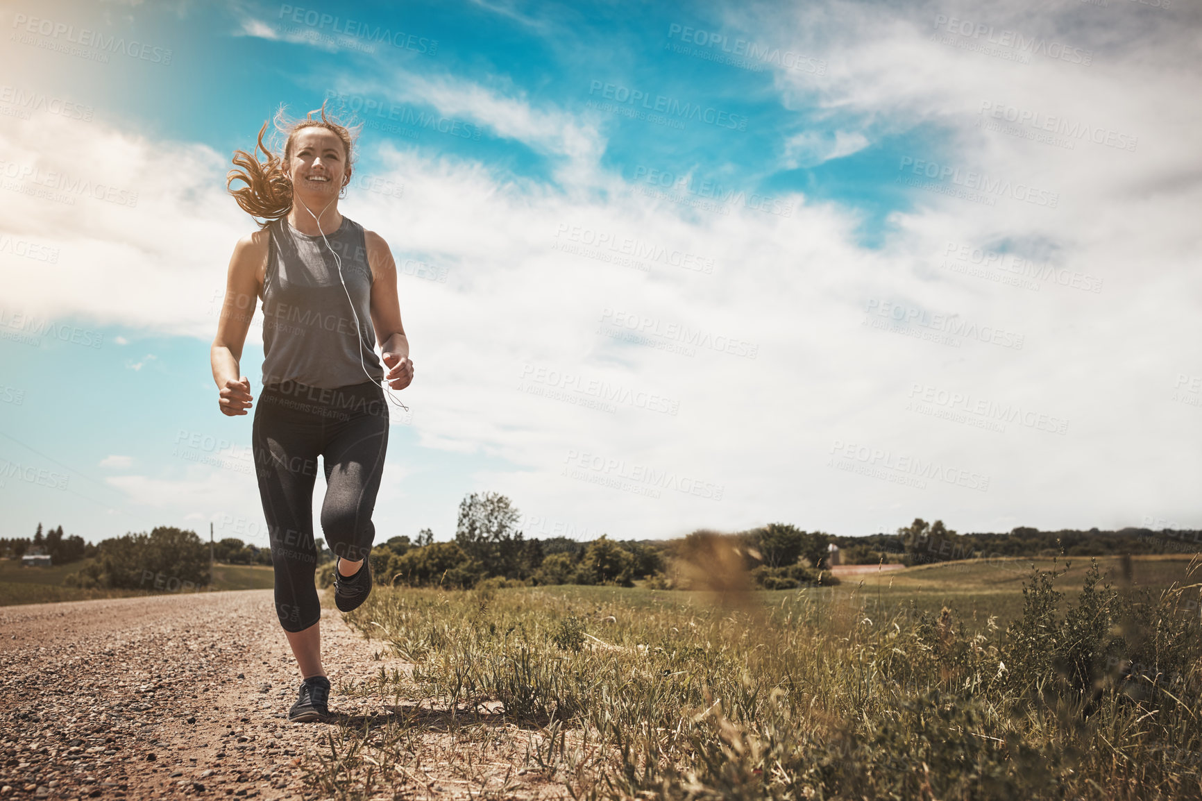 Buy stock photo Shot of a young woman out on a trail run