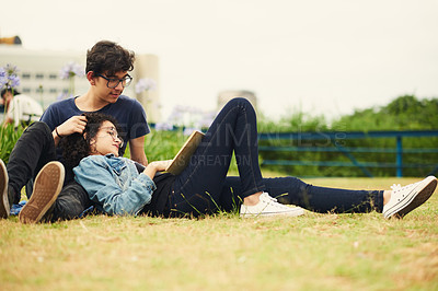 Buy stock photo Couple, teenager and relax in park for reading, bonding and book together on weekend with romance story. Boy, girl and happy for relationship, learning and fantasy novel outdoor with love connection