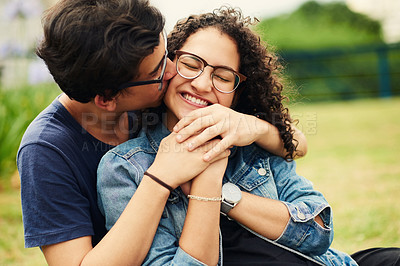 Buy stock photo Cropped shot of a teenage boy kissing his teenage girlfriend on the cheek outdoors