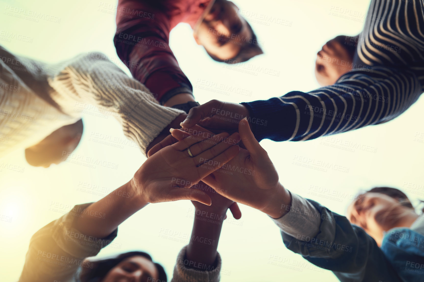 Buy stock photo Low angle shot of a group of students joining their hands in solidarity