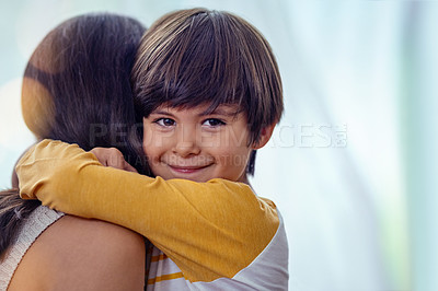Buy stock photo Shot of an adorable little boy affectionately hugging his mother at home