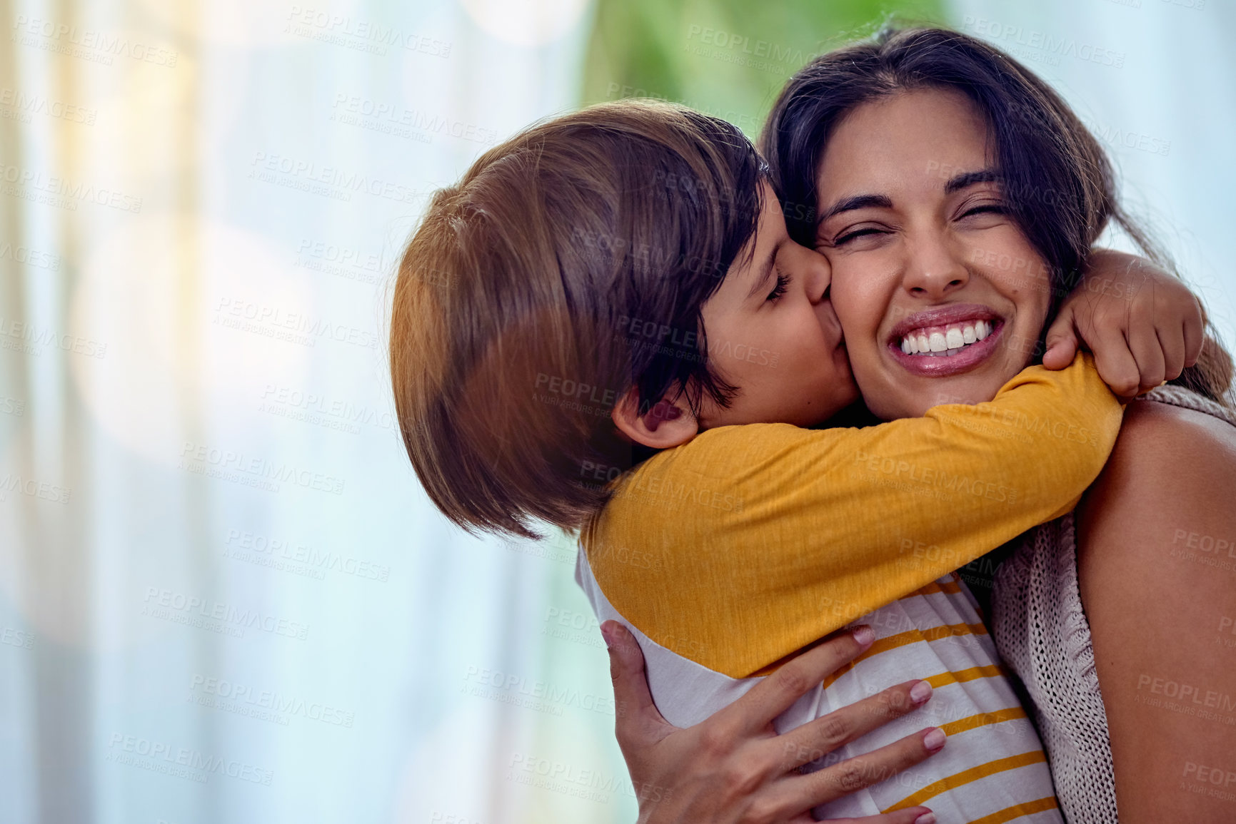 Buy stock photo Shot of an adorable little boy affectionately kissing his mother at home