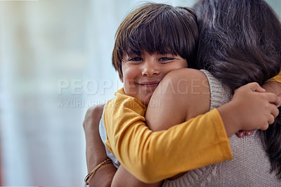 Buy stock photo Shot of an adorable little boy affectionately hugging his mother at home