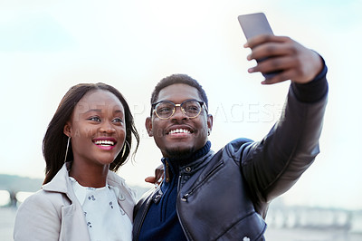 Buy stock photo Shot of an affectionate young couple taking selfies together outdoors