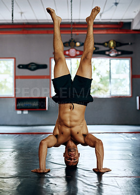 Buy stock photo Shot of a young man doing a handstand at the gym
