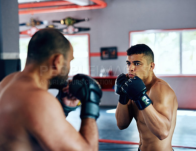 Buy stock photo Cropped shot of two male fighters training at the gym