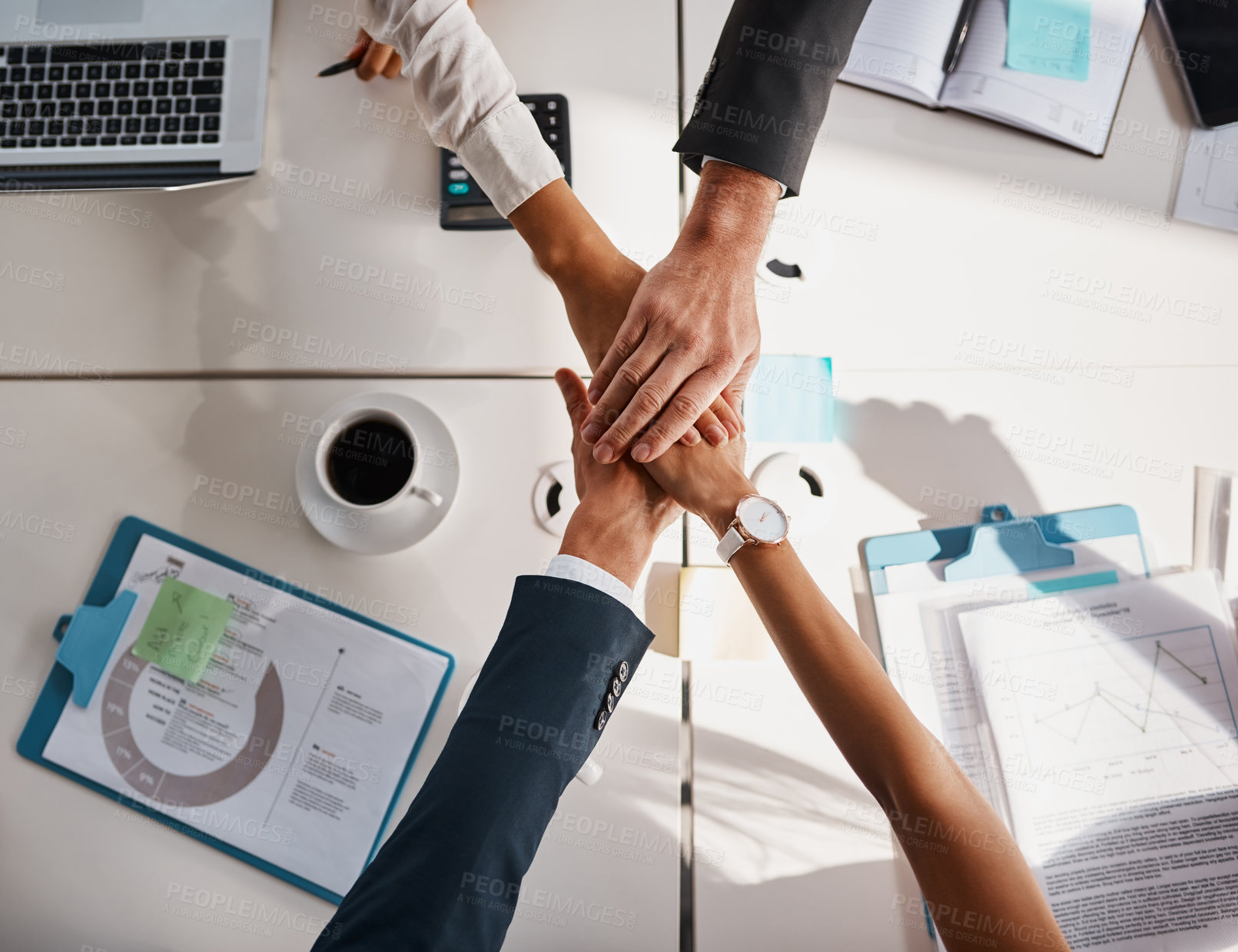 Buy stock photo High angle shot of unrecognizable corporate businesspeople joining their hands together in unity in the office