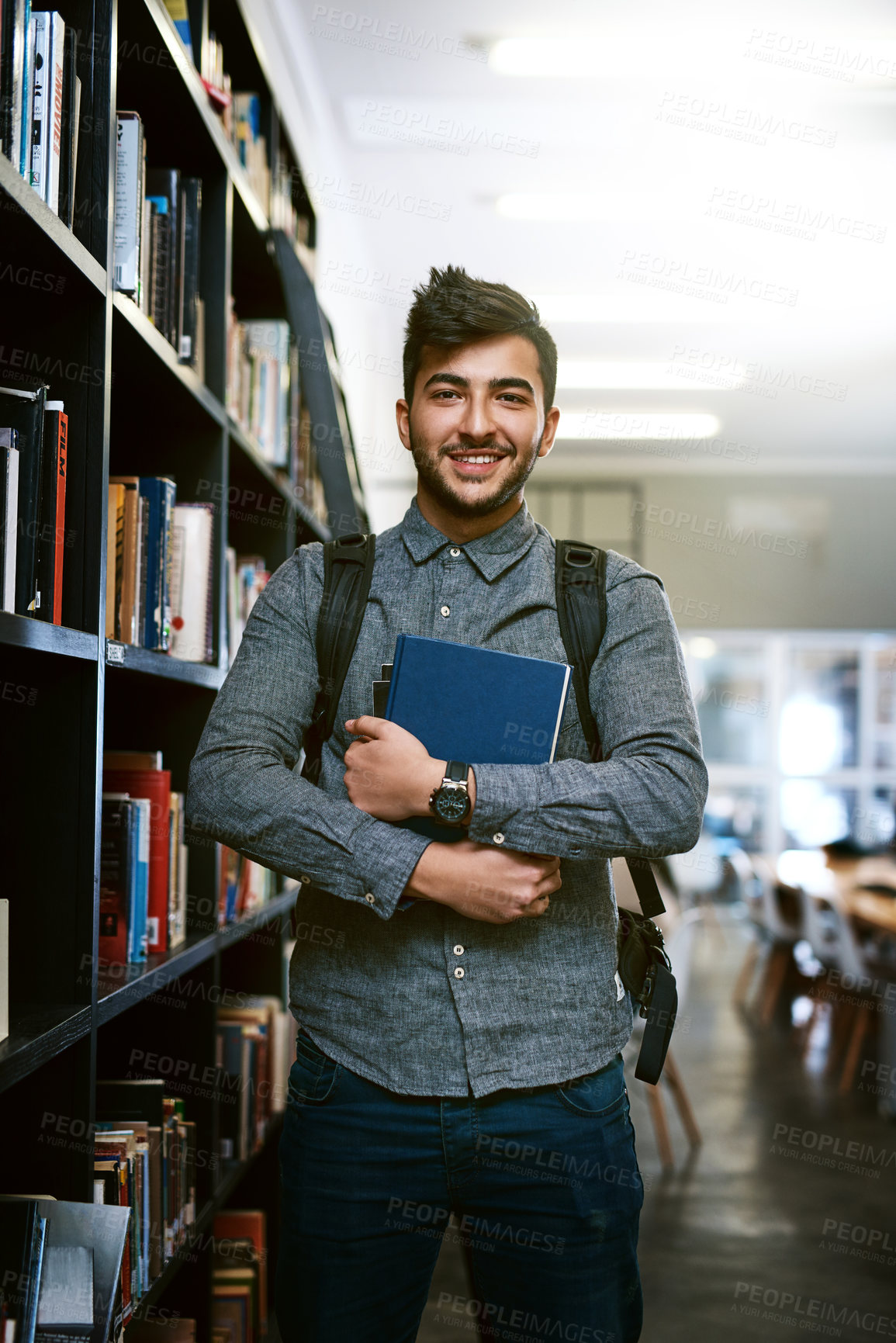 Buy stock photo Portrait of a happy young man carrying books in a library at college