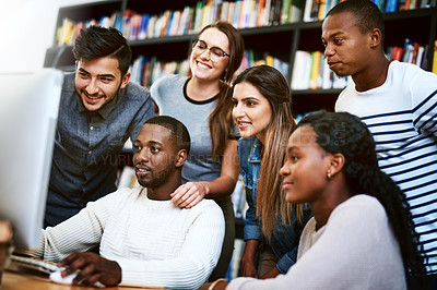 Buy stock photo Shot of a group of young students using a computer together in a college library