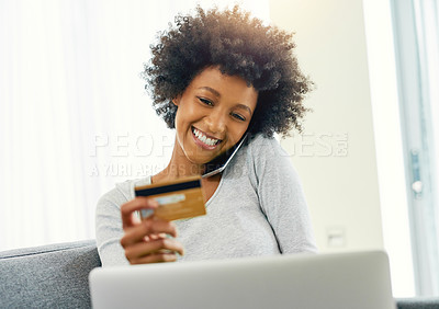 Buy stock photo Cropped shot of an attractive young woman using her laptop to shop online at home over the weekend