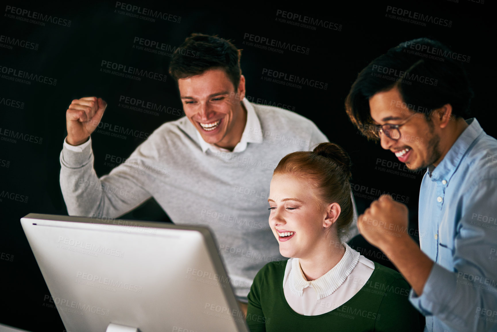 Buy stock photo Shot of a group of businesspeople cheering while working together in an office at night
