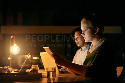 Buy stock photo Shot of a young businesswoman working on a digital tablet in an office at night