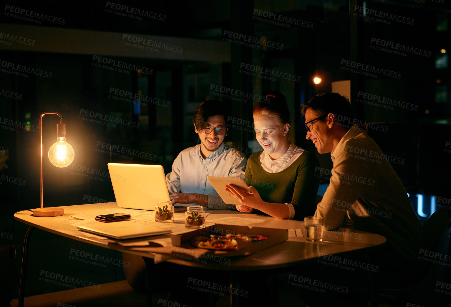 Buy stock photo Shot of businesspeople working together on a digital tablet in an office at night
