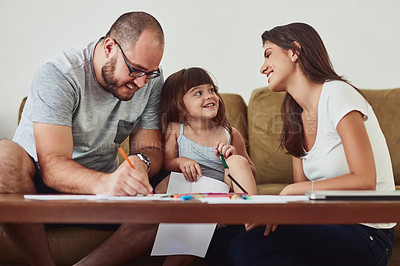 Buy stock photo Shot of a mother and father drawing together with their young daughter at home