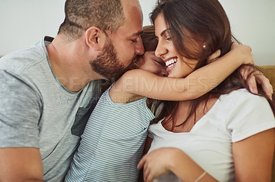 Buy stock photo Shot of a mother and father bonding with their adorable young daughter at home