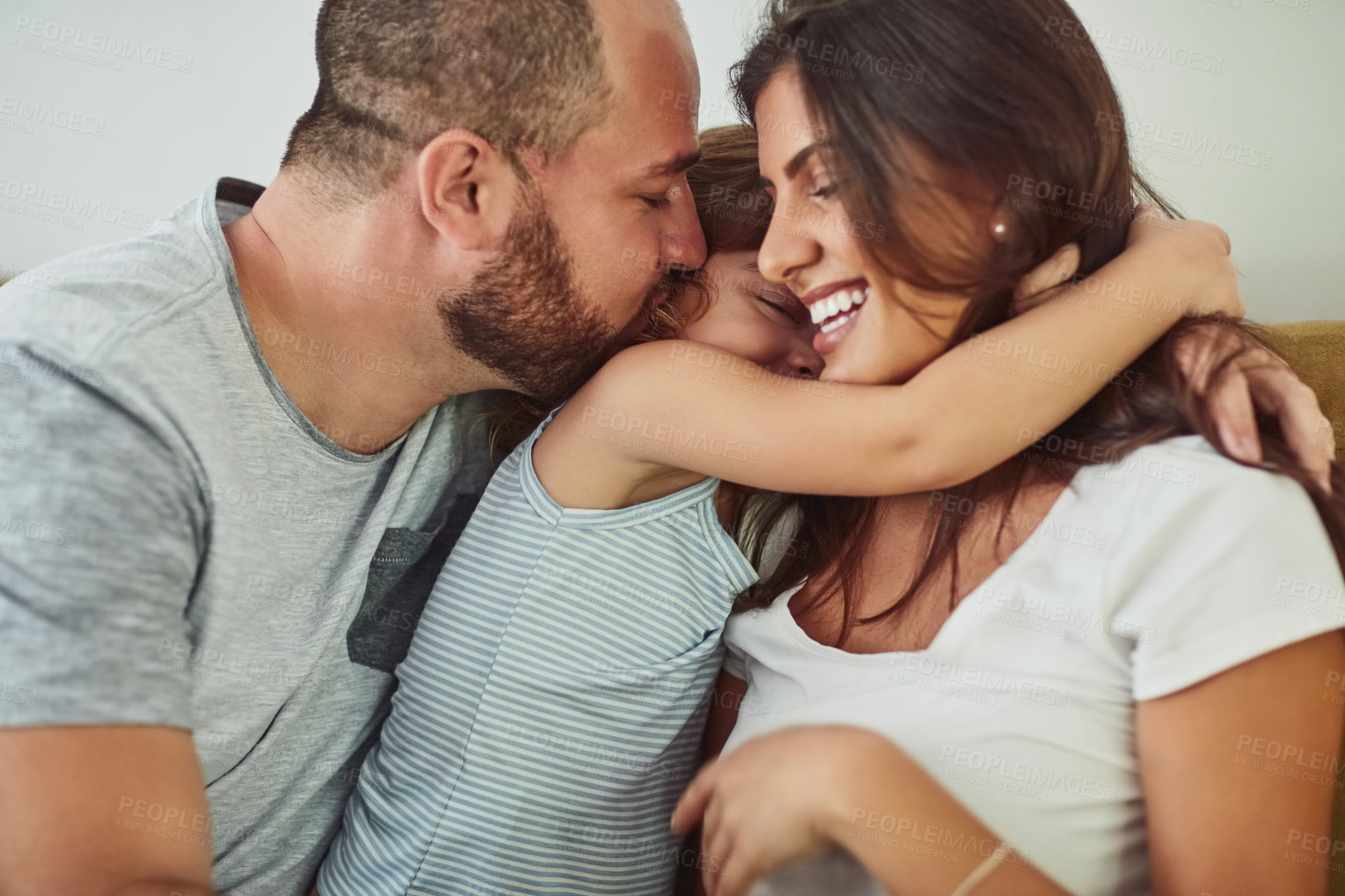 Buy stock photo Family, daughter and hug in home on sofa with smile for fun, bonding and support for child development. Parents, kiss and happy kid or girl in living room for love, relax and safety for memories