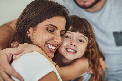 Buy stock photo Portrait of an adorable little girl hugging her mother with her father’s arm around them