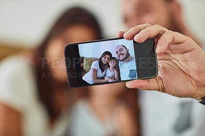 Buy stock photo Portrait of a mother and father taking selfies together with their young daughter at home