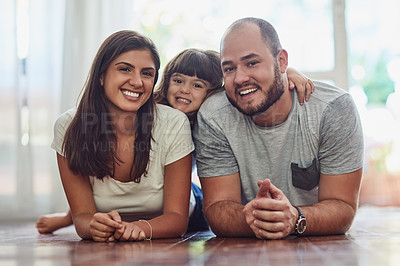 Buy stock photo Portrait of a mother and father bonding with their adorable young daughter at home