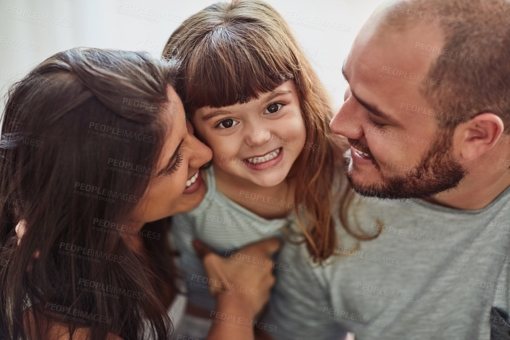 Buy stock photo Portrait of a mother and father bonding with their adorable young daughter at home