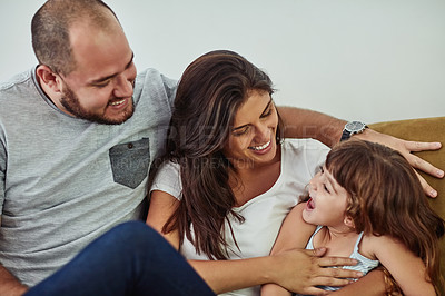 Buy stock photo Shot of a mother and father bonding with their adorable young daughter at home