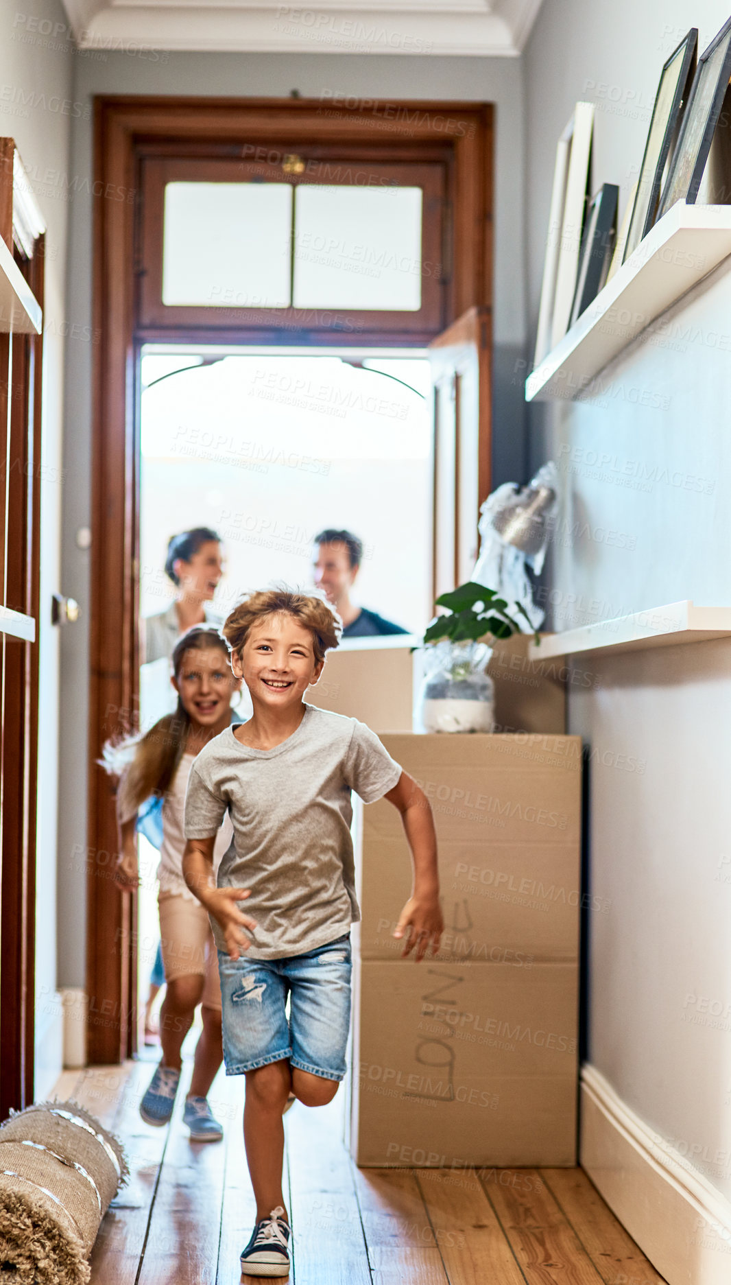 Buy stock photo Home, boy and girl running in a hallway, real estate and family with boxes, move and happiness. Parents, siblings and female kid with male child, smile and excited for new apartment, run and property