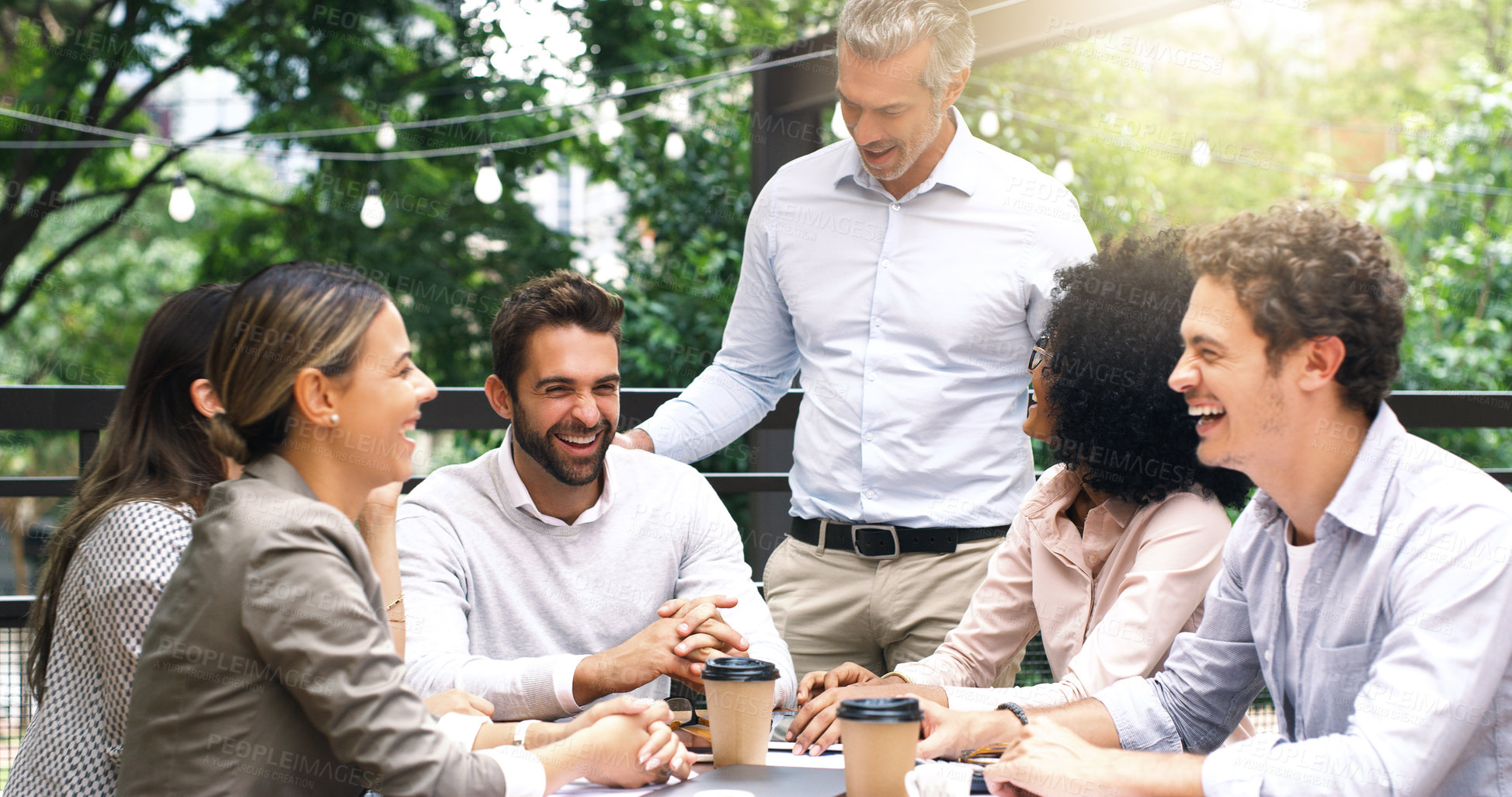 Buy stock photo Shot of a group of colleagues having a meeting at a cafe