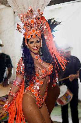 Buy stock photo Portrait of a cheerful female dancer wearing a vibrant costume while dancing inside a busy nightclub