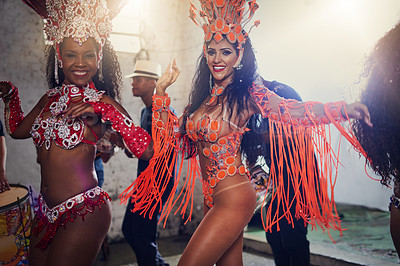 Buy stock photo Portrait of two female dancers wearing vibrant costumes while dancing to music inside of a busy nightclub