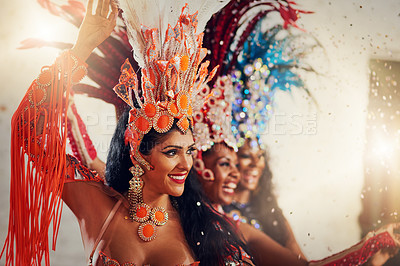 Buy stock photo Shot of a group of female dancers wearing vibrant costumes while dancing to music inside of a busy nightclub