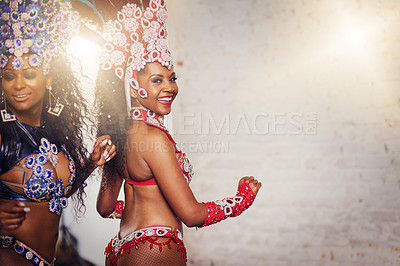 Buy stock photo Portrait of two female dancers wearing vibrant costumes while dancing to music inside of a busy nightclub