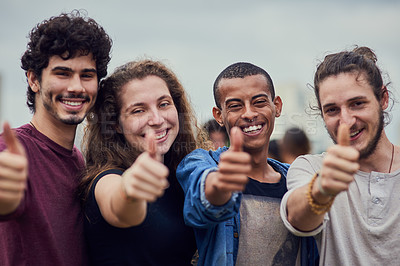 Buy stock photo Portrait of a group of young students showing thumbs up outside in a park during the day
