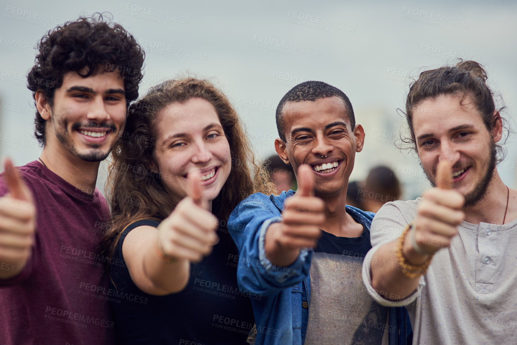 Buy stock photo Portrait of a group of young students showing thumbs up outside in a park during the day