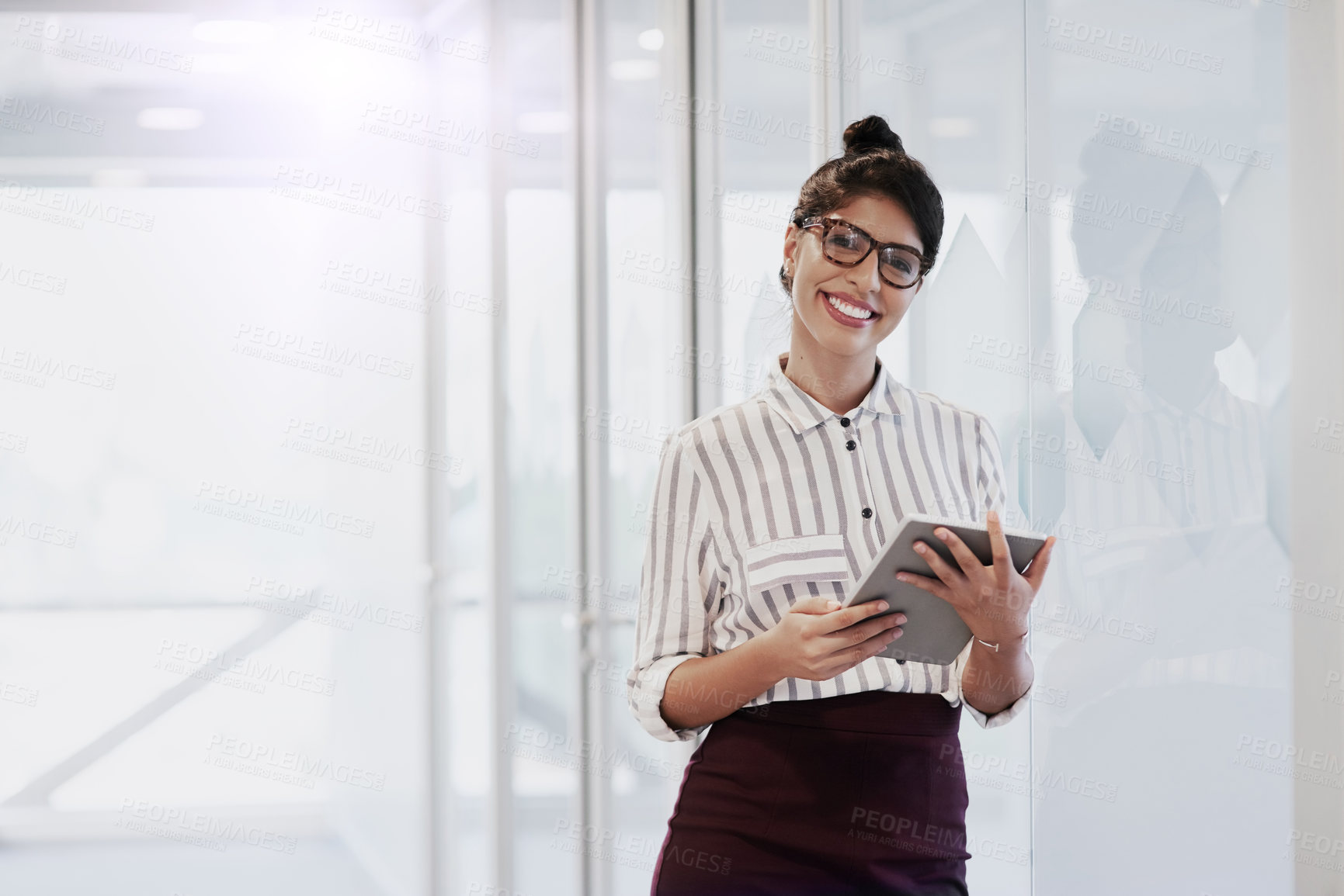 Buy stock photo Portrait of a confident young businesswoman using a digital tablet in an office