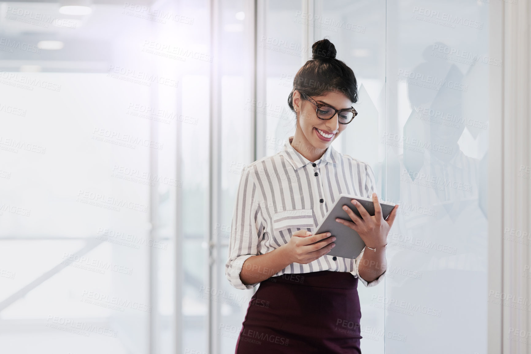 Buy stock photo Shot of a confident young businesswoman using a digital tablet in an office