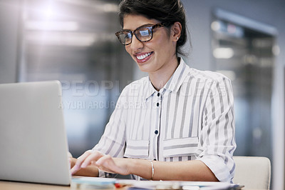 Buy stock photo Shot of a confident young businesswoman working on a laptop in an office