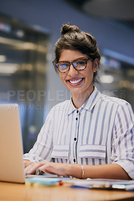 Buy stock photo Portrait of a confident young businesswoman working on a laptop in an office