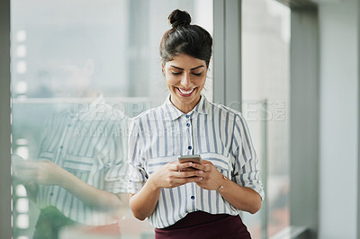 Buy stock photo Business woman, smile and phone text with happiness at office window with a email. Young female face employee and mobile connection of a worker feeling happy on social media and technology at company