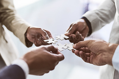 Buy stock photo Closeup shot of a group of unrecognizable businesspeople joining puzzle pieces together in an office